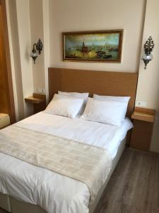a bed in a bedroom with a painting on the wall at Ottoman's Pearl Hotel in Istanbul