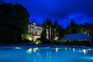 a swimming pool at night with a building in the background at Albergo La Primula in Potenza