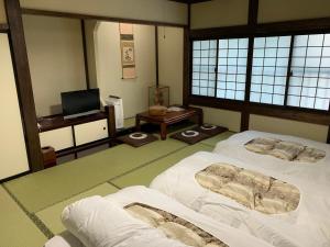 a room with two beds and a television in it at Ryokan Murayama in Takayama +58 photos