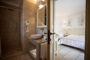 un bagno con doccia, lavandino e letto di Relais in Contrada a Lucera