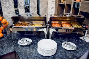 a buffet with plates and trays of food on a counter at Parallel Hotel in Baku