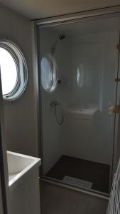 a bathroom with a shower stall and a toilet at Camping Aux Couleurs du ferret in Lège-Cap-Ferret