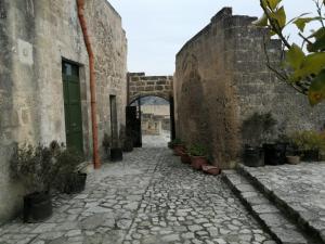 eine Gasse in einem alten Gebäude mit Topfpflanzen in der Unterkunft Il Carrubo residenza Walk&Stay in Matera