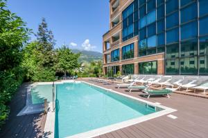 una piscina con tumbonas y un edificio en Hostellerie Du Cheval Blanc en Aosta