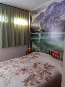 a bedroom with a painting of a lake and mountains at Centrale vicino cabinovia Magnolta e piscina in Aprica