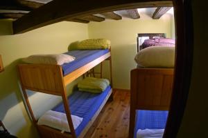 a room with three bunk beds in a room at Albergue Restaurante de Artieda in Artieda