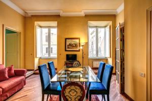 a dining room with a glass table and blue chairs at Charming Suite by the Vatican sx in Rome