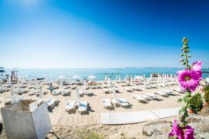 uma praia com cadeiras e guarda-sóis e o oceano em Prestige Sands Resort em Sunny Beach