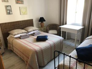 a bedroom with a bed and a table and a sink at Hôtel Restaurant Le Provençal in Le Grau-du-Roi