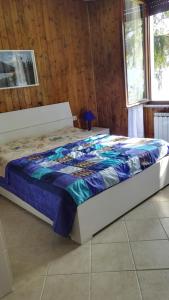 un letto con piumone blu in una camera di Casa Giuliana a Tremosine Sul Garda