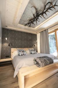 een slaapkamer met een bed met een wolvenhoofdeinde bij Domek Koliba pod Smrekami in Zakopane