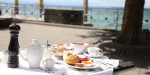 a table with a plate of food and a drink at Hotel Seepromenade in Meersburg