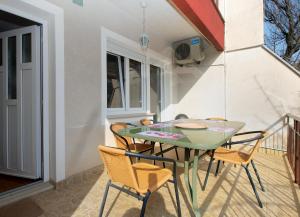 a green table and chairs on a balcony at Apartments Mira 1804 in Medulin