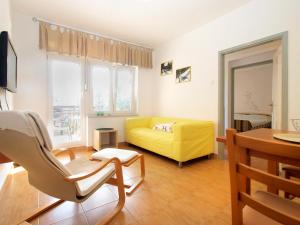 a living room with a yellow couch and a table at Apartments Mira 1804 in Medulin