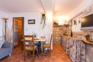 a kitchen and dining room with a table and a tv at The Terrace in Mošćenice