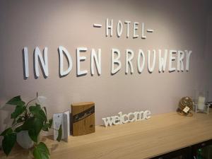 um sinal que lê hotel em der Brooklyn numa parede em Hotel In den Brouwery em Domburg