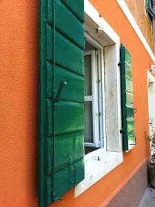 a window with a green shutter on the side of a building at Studios S in Zadar