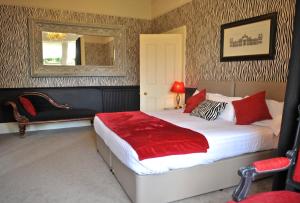 um quarto com uma cama grande e um espelho em Braid Hills Hotel em Edimburgo