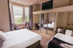 um quarto de hotel com duas camas e um espelho em Braid Hills Hotel em Edimburgo