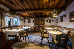 un restaurante con mesas, sillas y techos de madera en Hotel Gridlon en Pettneu am Arlberg