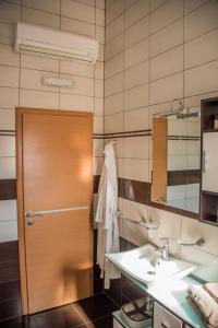 a bathroom with a sink and a wooden door at Medjugorje Apartment in Međugorje