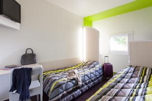 - une chambre avec 2 lits, une télévision et une fenêtre dans l'établissement ENZO Hotels 1er PRIX, à Châlons-en-Champagne