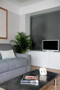 a living room with a couch and a tv at Joie Paris TOUR EIFFEL in Paris