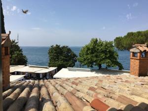 vista sul tetto di un edificio con l'oceano sullo sfondo di Welcome Traveller MERLO NERO APARTMENTS a Garda