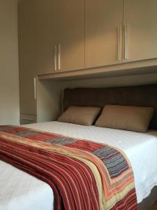 ガルダにあるWelcome Traveller MERLO NERO APARTMENTSのベッド(カラフルな毛布付)