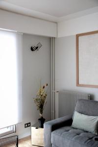 a living room with a gray couch and a window at Joie Paris TOUR EIFFEL in Paris