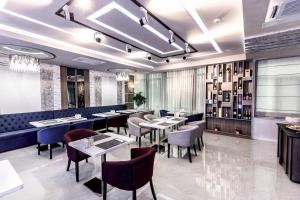 ein Restaurant mit Tischen und Stühlen in einem Zimmer in der Unterkunft Parallel Hotel in Baku