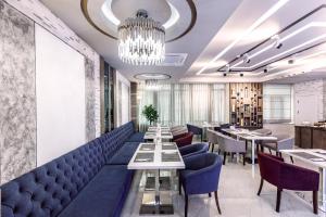 a restaurant with blue chairs and tables and a chandelier at Parallel Hotel in Baku