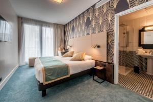a hotel room with a bed and a bathroom at Best Western Hôtel Journel Antibes Juan-les-Pins in Antibes