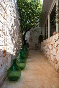 Tre vasi verdi allineati contro un muro di mattoni. di Masseria Oreglia a Ceglie Messapica