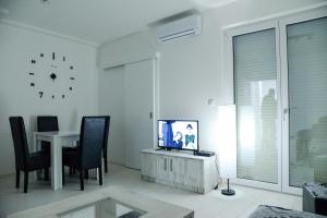 a living room with a tv and a table with chairs at BEST Apartments in Paraćin