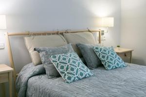 a bed with blue and white pillows on it at Blanc Guest House in Barcelona