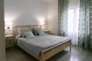 a bedroom with a bed with blue pillows and a window at Blanc Guest House in Barcelona