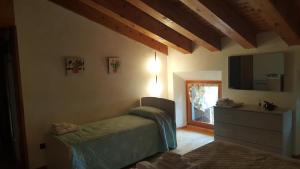 1 dormitorio con 1 cama y vestidor con espejo en La casetta di Chiara en Fumane