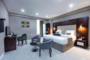 a hotel room with a bed and a desk and chairs at Parallel Hotel in Baku