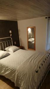 1 dormitorio con 1 cama grande y espejo en La carole, en Mosset