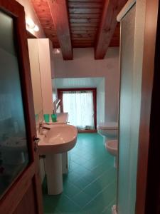 a bathroom with two sinks and two toilets at La casetta di Chiara in Fumane