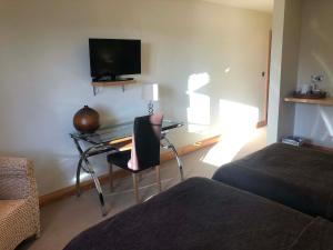 a bedroom with a desk with a tv and a chair at Castle Sleeper in Corby +17 photos