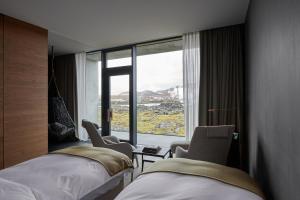 ein Hotelzimmer mit 2 Betten und einem großen Fenster in der Unterkunft The Retreat at Blue Lagoon Iceland in Grindavík