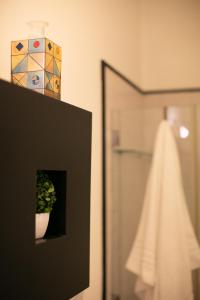 a bathroom with a shower and a vase with a plant at Residenza L'isola - Il Chiostro by Dimorra in Naples