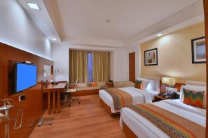 a hotel room with two beds and a flat screen tv at Fortune Park Orange, Sidhrawali - Member ITC's Hotel Group in Bhiwadi