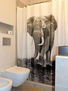 - un rideau de douche d'éléphant dans la salle de bains pourvue de toilettes dans l'établissement Sa Tuna "Casas CE MA", à Begur