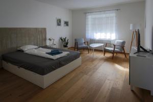 a bedroom with a bed and a table and chairs at Flataid Apartmenthaus Brauhausstrasse in Graz