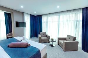 a hotel room with a bed and a chair at Parallel Hotel in Baku