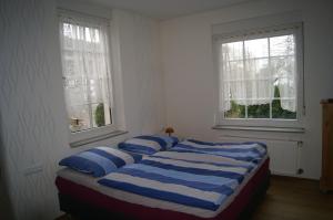 a bedroom with a bed with blue and white pillows at Pension Oberberg in Lindlar