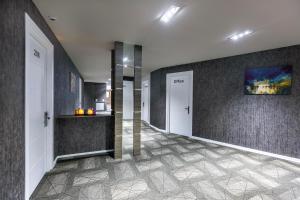 a hallway with two white doors and a wall at Parallel Hotel in Baku